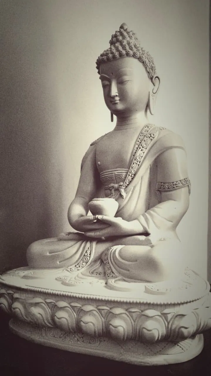 Sepia-toned photograph of the matte grey Buddha statue on its lotus base.