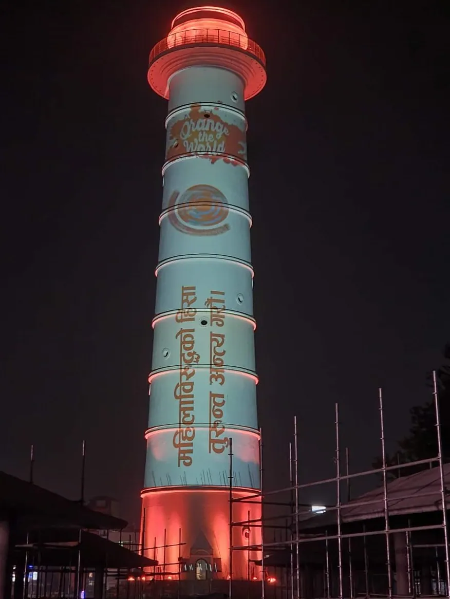 The tower lit in orange with an Orange the World logo and a Nepali line about ending violence against women projected on its shaft.